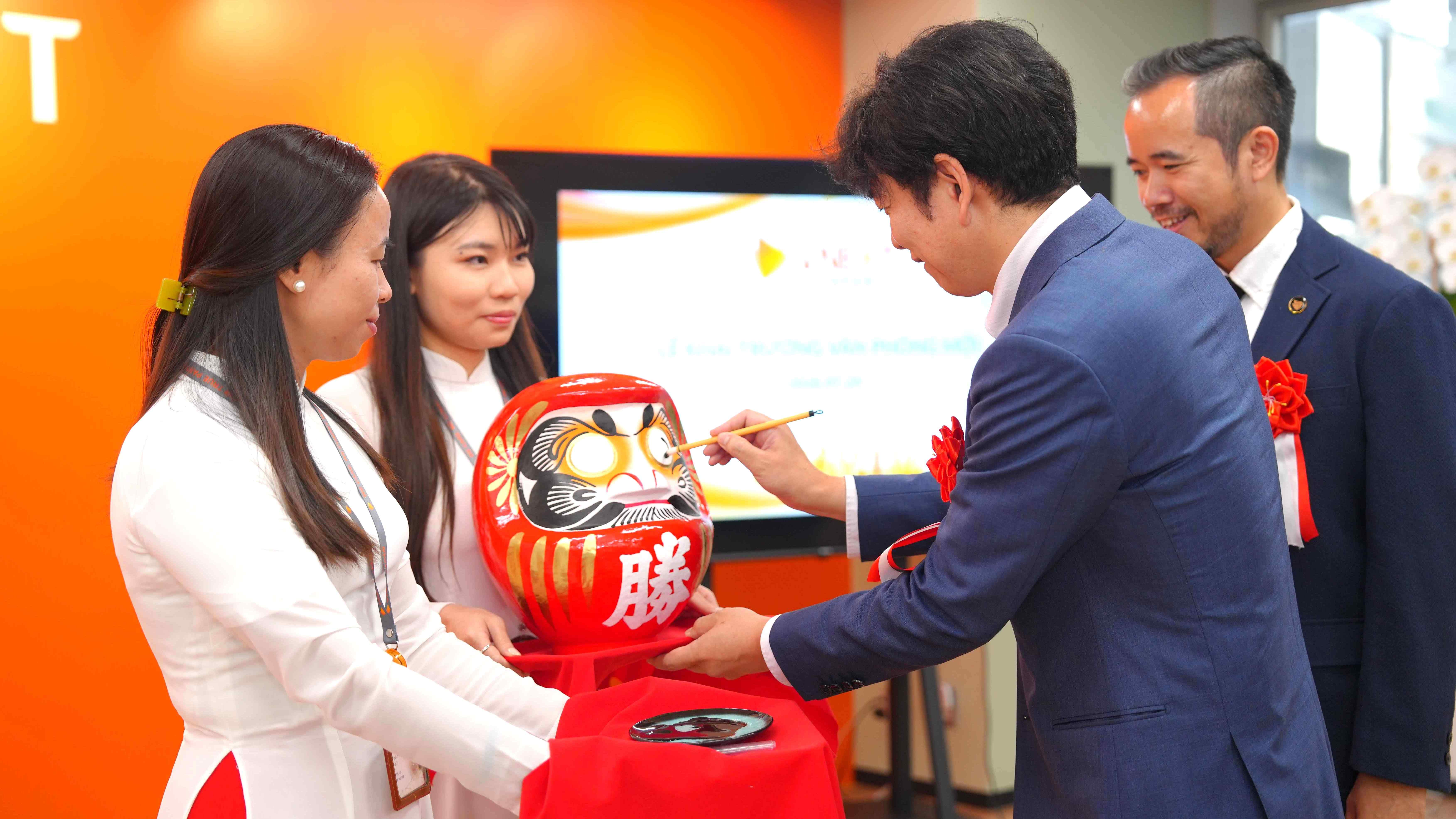 VNEXT JAPAN leadership painting the eye of a Daruma doll at the Tokyo office opening ceremony